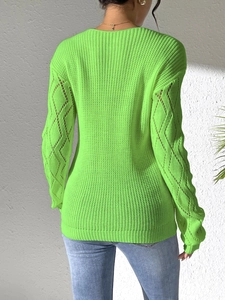 Detail view of neon green knitted sweater with hollow diamond lace crochet on back and sleeves