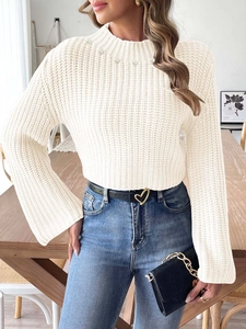 Détail d'un pull court en maille avec perles brodées et manches évasées élégantes