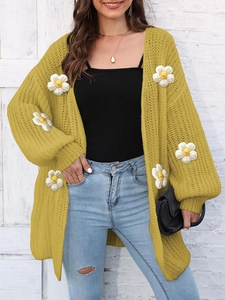 Detail of yellow chunky knit cardigan featuring 3D white daisy crochet appliques for women