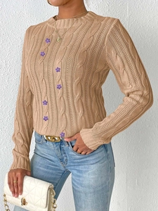 Detail of cable knit sweater with 3D purple flower appliques and ribbed crew neck