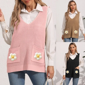 Detail of V-neck knitted vest with textured stitch and 3D floral accent on front pockets