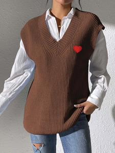 Detalle de chaleco de punto con cuello en V, bordado de corazón y textura de punto
