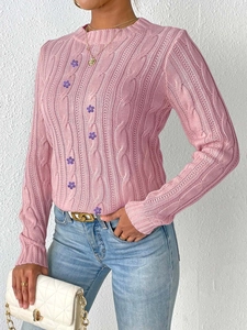 Detail of pink cable knit sweater with 3D purple flower appliques and round neck