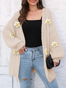 Close-up of cream chunky knit cardigan featuring 3D yellow daisy floral embroidery