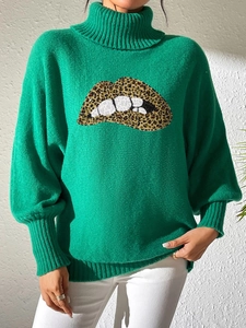 Detail of green turtleneck sweater with sequined leopard lips pattern on knit fabric
