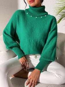 Detail of high collar green knit sweater featuring white pearl trim and puff lantern sleeves