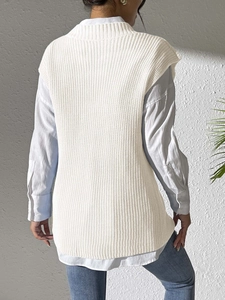 Detail of white sleeveless knit vest with vertical texture over a light blue shirt