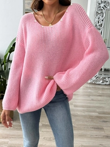 Detailed close-up of pink oversized knit sweater with elegant pearl neckline and bell sleeves