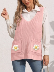 Detail of hand-crocheted floral pocket on a pink V-neck knit vest sweater