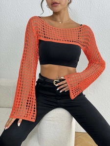 Detail of bright orange crochet beach cover-up featuring retro flared sleeves and hollow knit