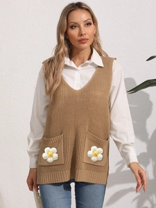 Detail view of khaki knit vest featuring V-neck and handmade crochet daisy on pockets