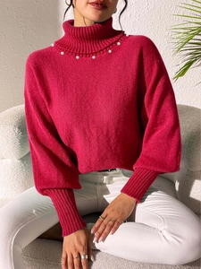 Detailed view of rose red high neck sweater with pearl beads and lantern sleeve cuffs
