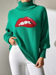 Detail of red sequined lip pattern on green turtleneck knit sweater for women