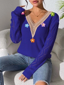 Detail of V-neck lace trim and colorful 3D flower appliques on navy blue knit sweater