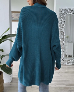 Close-up of peacock blue chunky knit sweater featuring high neck and vertical rib texture