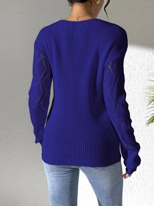 Detail of royal blue knit sweater with diamond hollow-out sleeves and tight knit texture