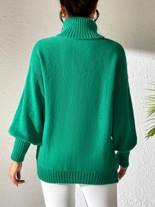 Detail of bright green turtleneck sweater with loose puff sleeves and ribbed cuffs