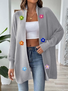Détails de fleurs au crochet 3D sur un cardigan gris en maille à manches lanternes