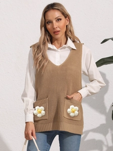 Close-up of knit vest featuring V-neck design and pockets with handcrafted floral details