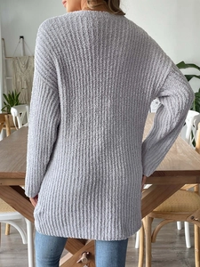 Détail macro de la texture en maille épaisse et du tissu doux sur le cardigan gris