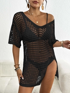 Détail de la robe de plage au crochet noir avec maille ajourée et fente latérale
