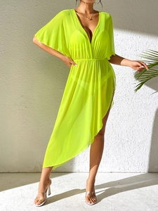Detail view of the asymmetric hem and sheer mesh fabric of the neon beach cover-up dress
