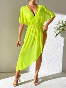 Detail of neon beach cover-up featuring deep V-neckline and sheer chiffon texture