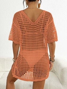 Détail du tissage au crochet orange sur une robe de plage avec col en V