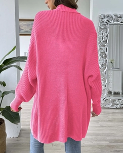 Detail of hot pink oversized knit sweater featuring a ribbed turtleneck and thick texture