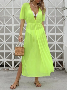 Detail of neon green sheer beach cover-up featuring deep V-neck and high side slit design