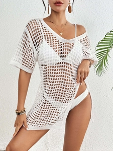 Détail de la texture en maille crochetée blanche et fente latérale de la robe de plage