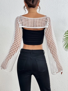 Detail of white crochet knit shrug showing hollow out mesh pattern and flared long sleeves