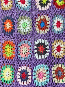 Dettaglio del ricamo boho fatto a mano all'uncinetto con quadrati colorati vivaci