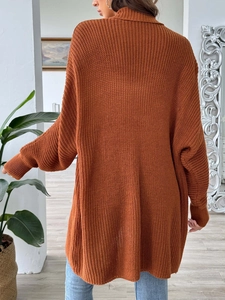 Détail d'un cardigan en maille épaisse orange caramel avec une coupe ample et décontractée