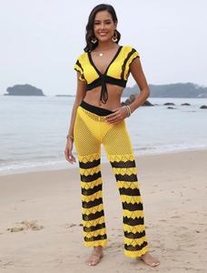 Detail of yellow and black crochet beach set featuring a V-neck crop top and flared pants