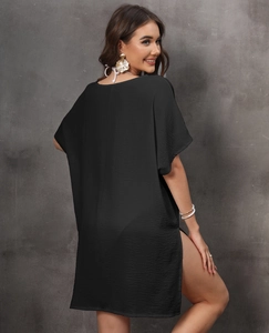 Detail of loose black beach cover-up featuring flowing fabric and side slit