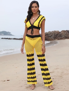 Detail of yellow knit crochet beach trousers with hollow mesh and wave texture