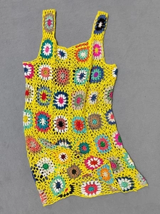 Dettaglio dell'abito boho lavorato all'uncinetto con motivi floreali a quadretti colorati
