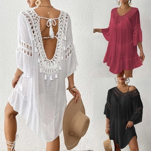 Detailed crochet patterns and tassel accents on a backless V-neck beach cover-up dress