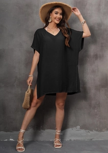 Detail of V-neckline and textured black fabric on this loose side-slit beach cover-up dress