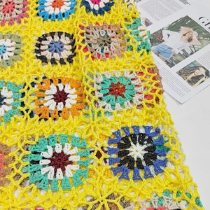 Dettaglio di un top giallo all'uncinetto fatto a mano con motivi floreali bohémien