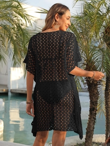 Detail of sheer black crochet lace beach cover-up with polka dot patterns and tie-back design
