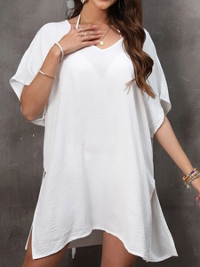 Detail of white V-neck cover-up dress showing textured fabric and loose side slits
