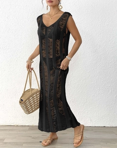 Detail of black crochet knit long dress with vertical openwork pattern for summer beach
