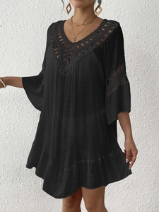 Detail of black V-neck beach cover up featuring crochet lace trim and bell sleeves
