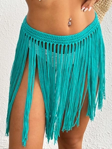 Detailed texture of turquoise crochet beach cover-up skirt with bohemian fringe tassels
