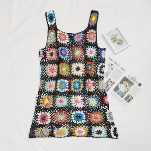 Dettaglio flat lay di un abito da spiaggia boho all'uncinetto con quadrati colorati