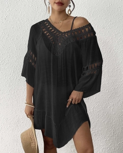 Detail of black beach cover-up with crochet lace V-neck and boho tassel details