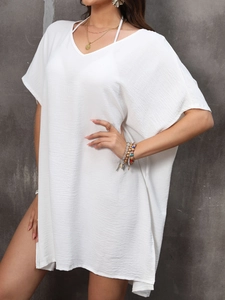 Detail of white V-neck cover-up dress featuring textured fabric and batwing sleeve design