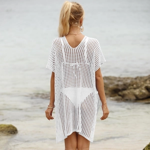 Detail of white crochet beach cover-up featuring open-knit mesh texture and lace-up back